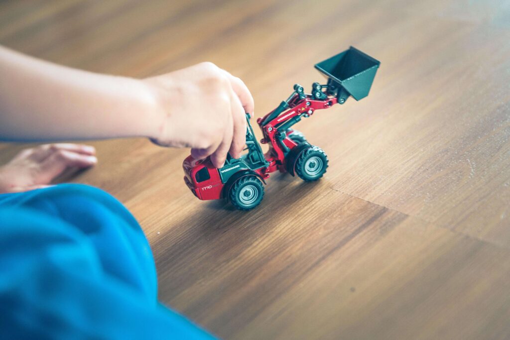 child playing with a toy tractor at nursery